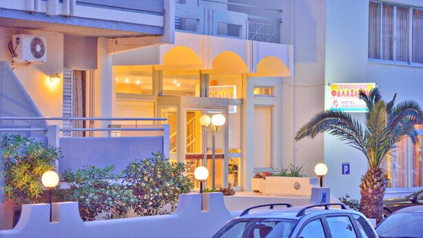Un hotel con fachada moderna, entrada visible y cartel que indica que es un hotel.