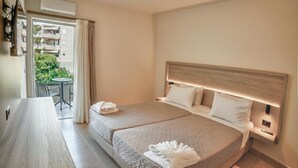 Habitación de hotel con cama, escritorio y vistas al exterior.