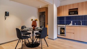 A modern kitchen with wooden cabinets, a built-in microwave, and a stove. - Incredible Loft in Centro walk to Zócalo (Mexico City)