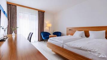Une chambre d’hôtel avec un lit en bois, un bureau, une chaise et une lampe.