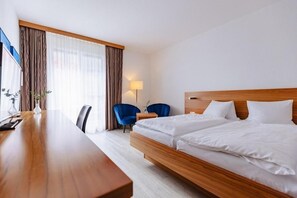 A hotel room with a wooden bed, a desk, a chair, and a lamp. - Rossli Hurden (Freienbach)