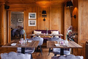 A restaurant with wooden walls, a sofa, and tables set for dining. - Rossli Hurden (Freienbach)