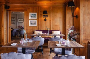 Un restaurante con paredes de madera, un sofá y mesas dispuestas para comer.