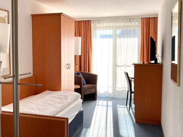 A hotel room with a bed, a desk, a chair, and a wardrobe. - Rossli Hurden (Freienbach)
