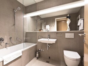 Un baño moderno con bañera, ducha, lavabo e inodoro.