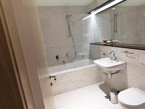 Un baño moderno con bañera, lavamanos e inodoro.