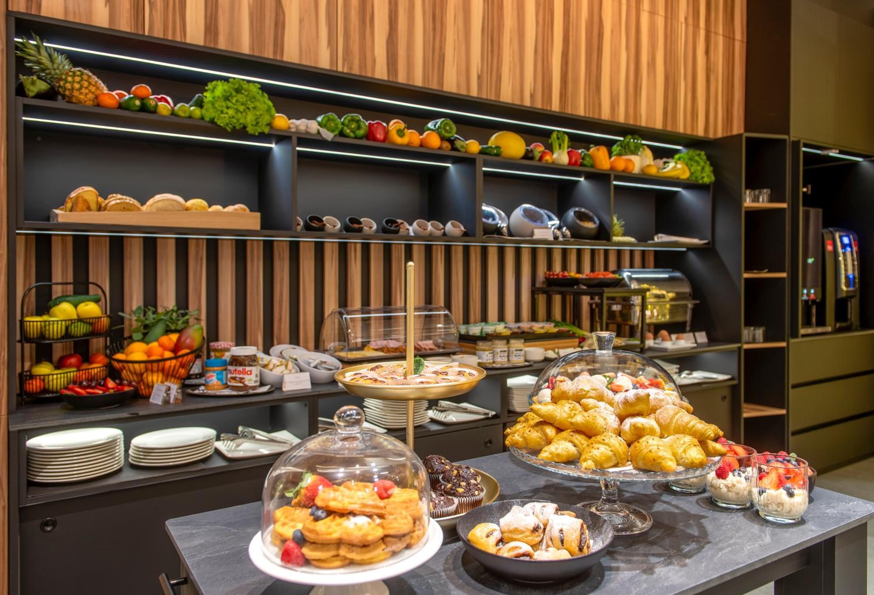 A buffet with various food items, including fruits, pastries, and desserts.