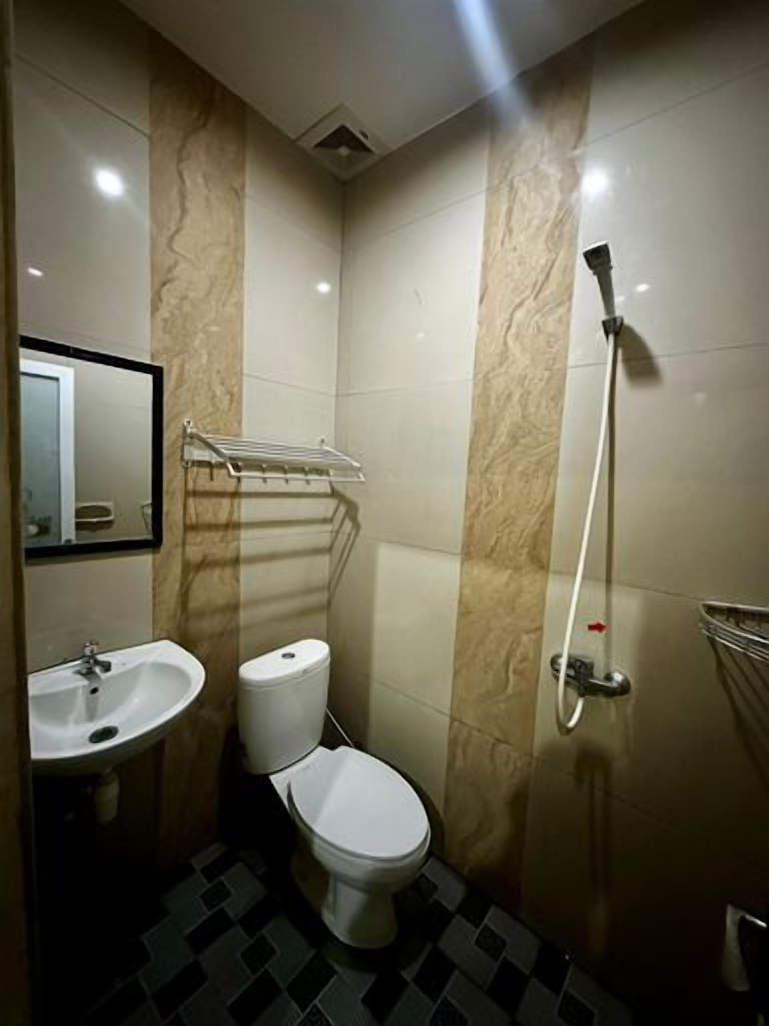 A bathroom with a toilet, sink, and shower.