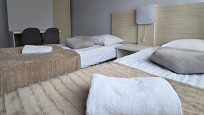 A hotel room with two beds, a desk, and a chair. - Noclegi Gwardia (Koszalin)