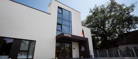 Un moderno edificio de hotel con fachada plana, ventanas amplias y un cartel que indica que es un hotel.
