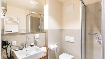 Ein Badezimmer mit Waschbecken, Spiegel, Toilette und Dusche.