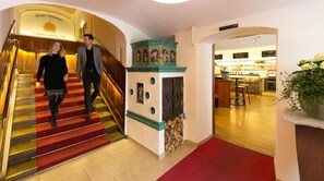 Un vestíbulo de hotel con una escalera, una recepción y una zona de bar.