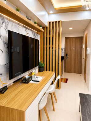 A modern kitchen with a marble backsplash, wooden counter, and a large flat-screen TV. - Luxury Stay for Less • Cozy Vibes + Epic Sunsets (Pasay City)