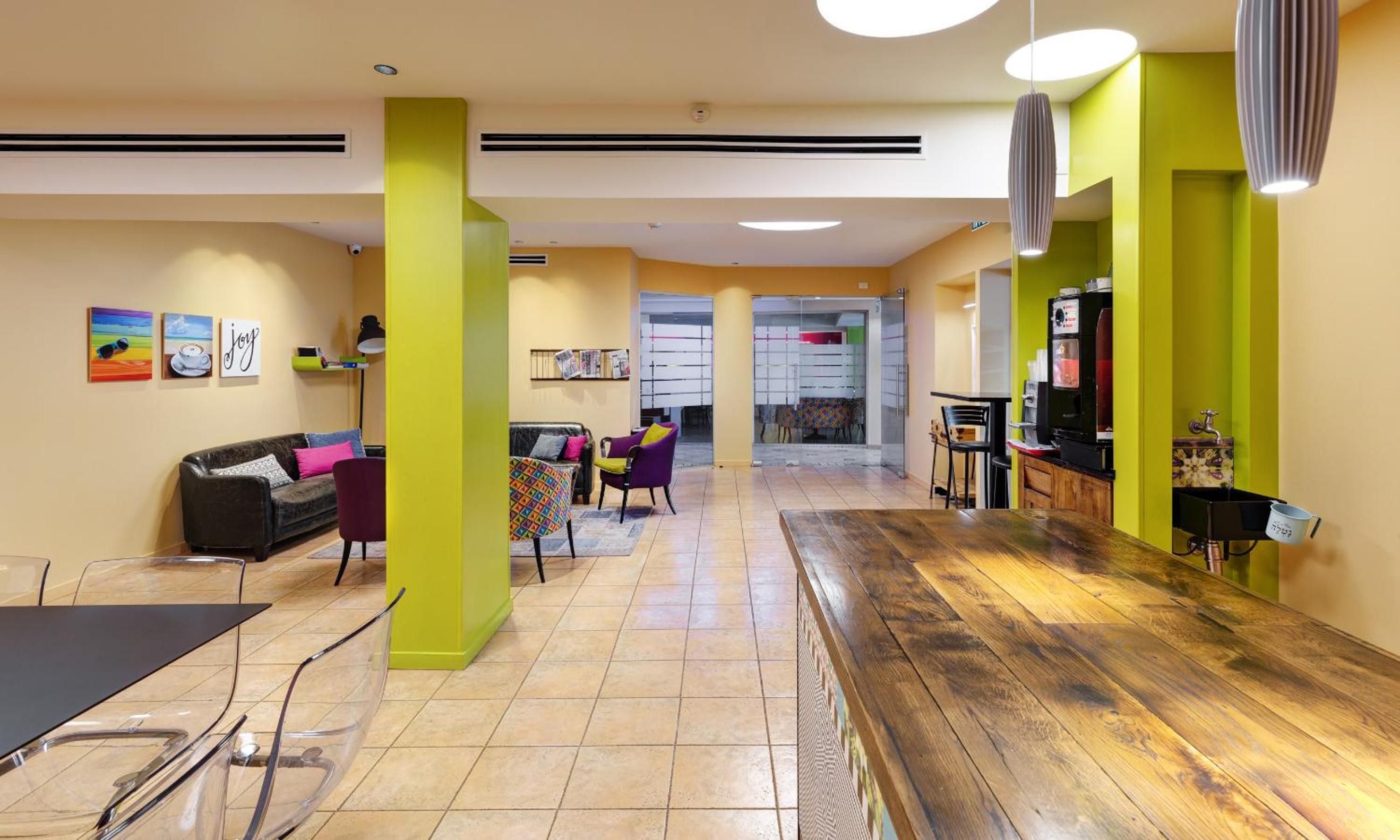 A modern interior with a wooden floor, a sofa, a table, and chairs.