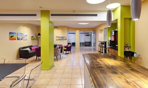Un interior moderno con piso de madera, un sofá, una mesa y sillas.