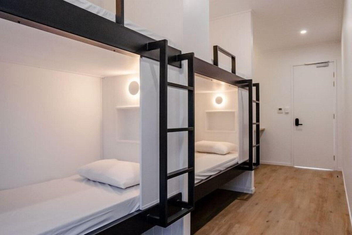 A bunk bed room with a door and a light fixture.