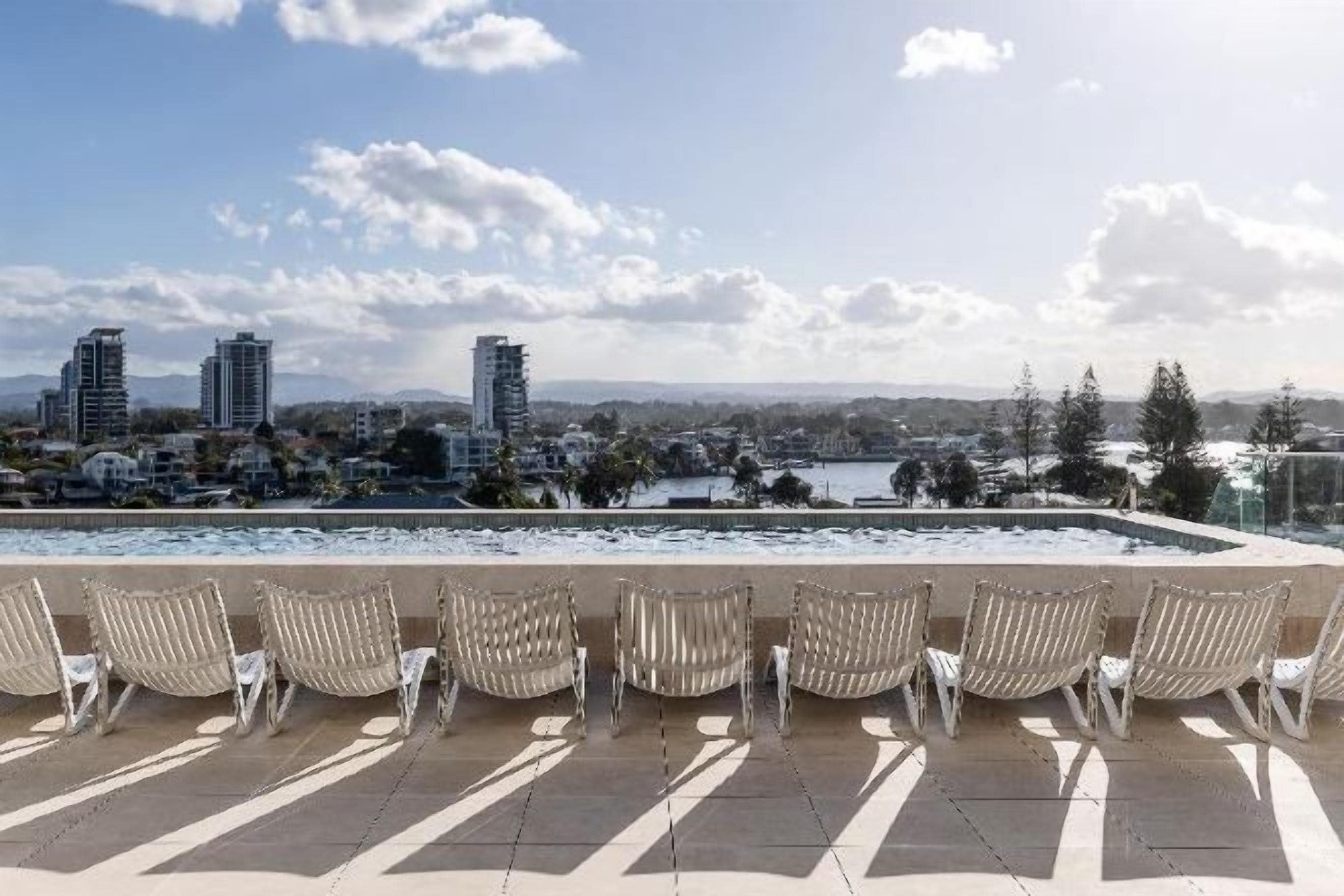 Terraço no telhado com espreguiçadeiras e vista para a cidade.