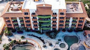 Un hôtel à plusieurs étages doté de balcons, d’une cour intérieure avec des piscines et d’espaces de détente en plein air.