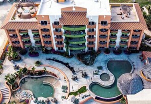 Un hôtel à plusieurs étages doté de balcons, d’une cour intérieure avec des piscines et d’espaces de détente en plein air.