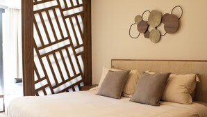 A neatly made bed with a headboard, a wall-mounted decorative piece, and a wooden partition. - Paravian 107A 1BR Condo Playa del Carmen (Playa del Carmen)