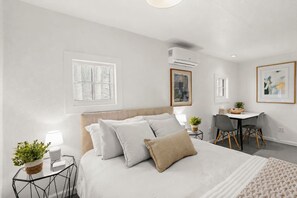Ein Schlafzimmer mit Bett, Nachttischen, Schreibtisch und Stühlen.