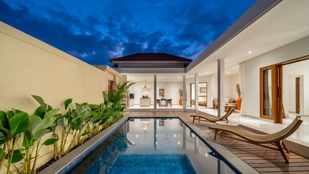 A modern pool area with a clear view of the pool, lounge chairs, and a dining area. - Kubung Villa Bali (Kerobokan)