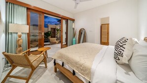 A bedroom with a bed, a chair, a ceiling fan, and a view of the outside. - Kubung Villa Bali (Kerobokan)