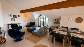 Ein modernes Wohnzimmer mit Essbereich, Kamin und großem Fenster.