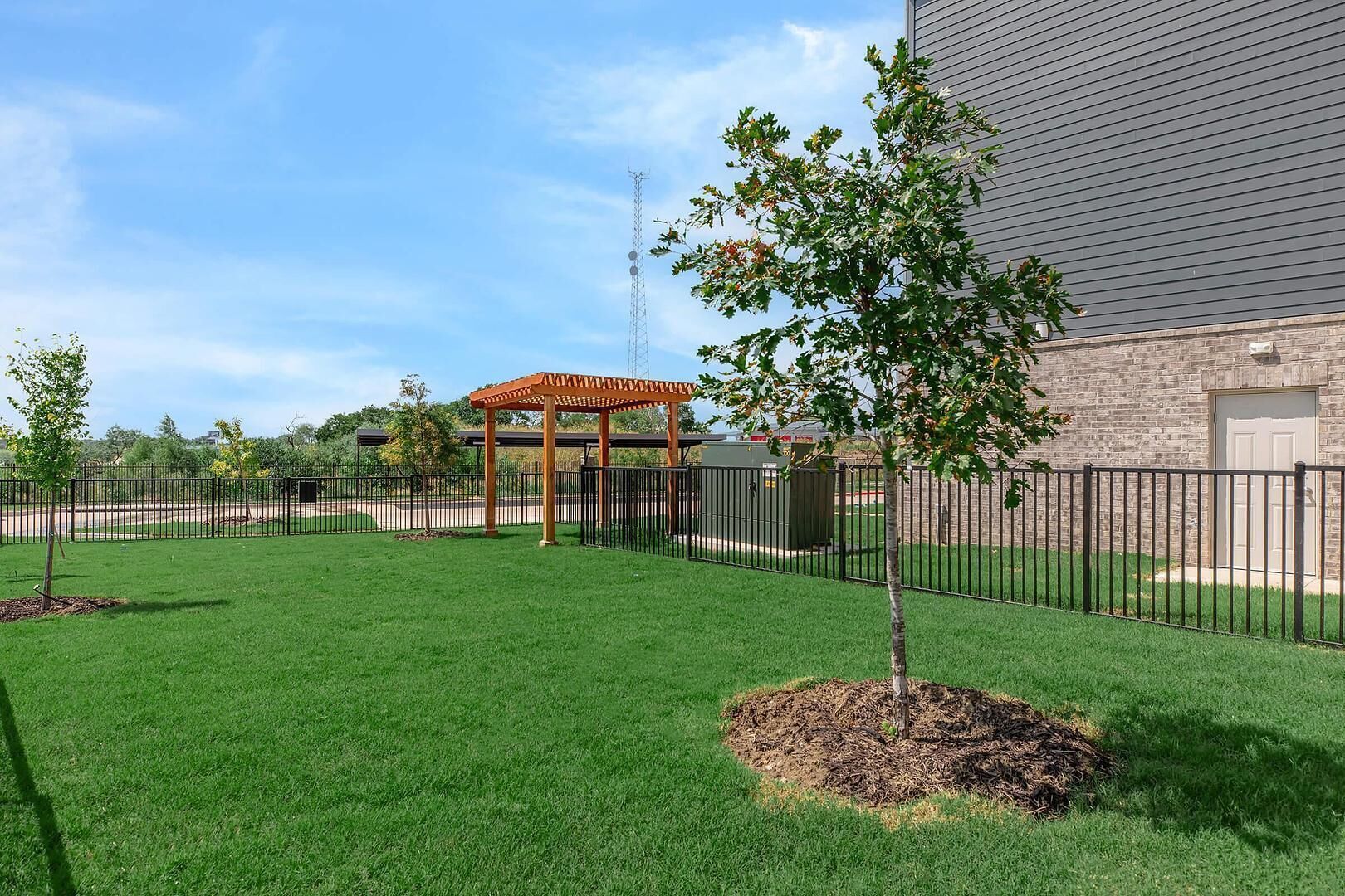 Un espace verdoyant bien entretenu, agrémenté d’une pergola en bois et d’un jardin clos.