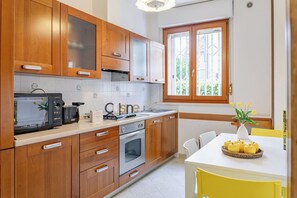 Una cocina moderna con armarios de madera, un microondas, una estufa y un lavamanos.