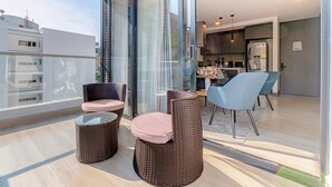 A modern balcony with wicker furniture, a glass table, and a view of the cityscape. - Edificio Riomaggiore City Tower (Cali)