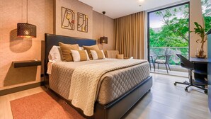 Une chambre moderne avec un grand lit, un bureau et une vue sur la verdure.