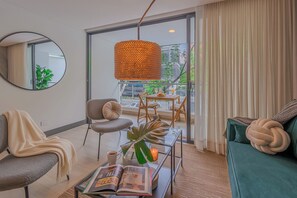 Uma sala de estar moderna com sofá, poltrona, mesa de centro e um espaço de jantar com mesa e cadeiras.