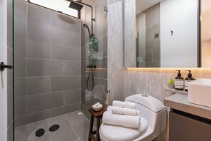 A modern bathroom with a glass-enclosed shower, a white toilet, a sink, and a mirror. - Edificio Riomaggiore City Tower (Cali)