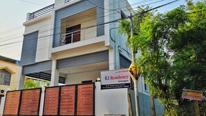 A multi-story residential building with a sign for RJ Residency.