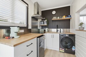 A compact kitchen with a coffee maker, microwave, sink, and dishwasher. - Airport Studio Retreat (Midway Point)