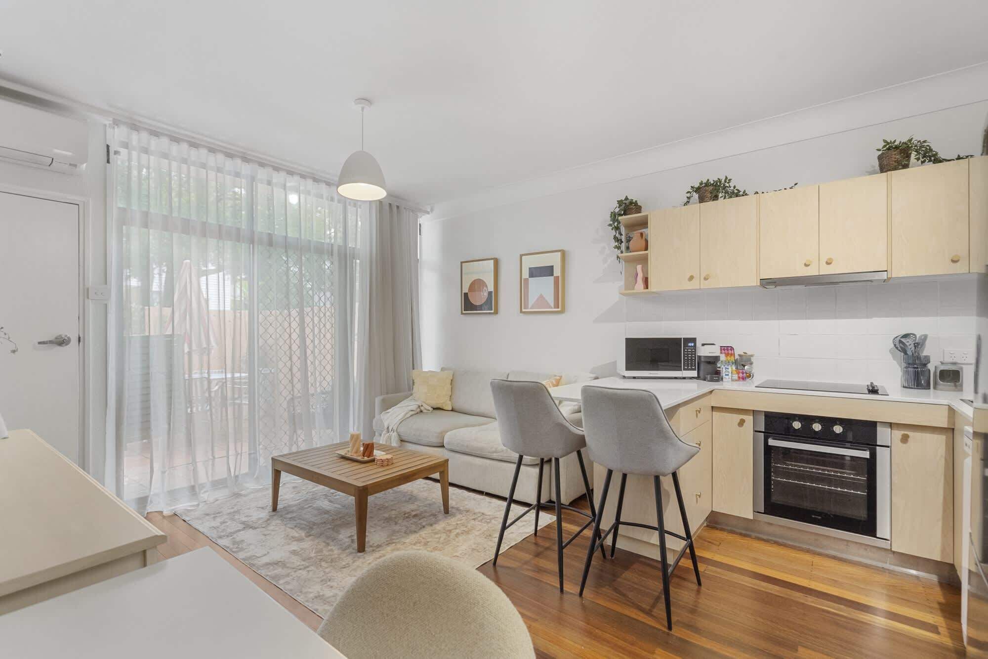 A compact living space with a kitchenette, a dining area with a table and chairs, and a sofa.