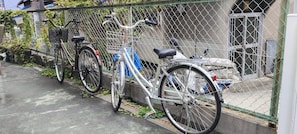 Ein Maschendrahtzaun, hinter dem Fahrräder abgestellt sind.