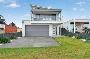 A modern two-story house with a garage, a balcony, and a stone wall. - 35A Franklin Pde Encounter Bay (Encounter Bay)