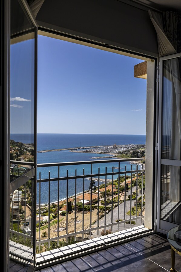 Ein Balkon mit Blick auf das Meer und eine Küstenstadt.