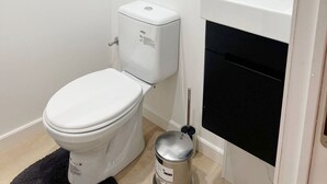 A small bathroom with a toilet, a sink, and a mirror. - Cozy 1BR & Living Room Near City Center (Ghent)