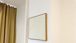 A room with a beige curtain, a white wall, and a framed artwork. - Cozy 1BR & Living Room Near City Center (Ghent)