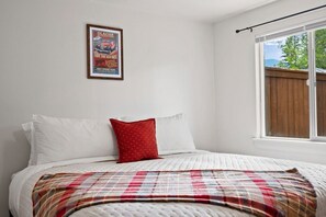 Une chambre à coucher avec un lit, une fenêtre et une affiche accrochée au mur.