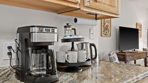 A kitchen with a coffee maker, cups, and a television. - Family Stay Near Glacier + Whitefish w/ Pickleball (Columbia Falls)