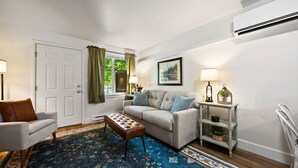 A living room with a sofa, armchair, ottoman, patterned rug, and a side table with a lamp. - Glacier NP Retreat w/ Modern Comforts & Pickleball (Columbia Falls)