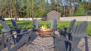 An outdoor seating area with Adirondack chairs and a fire pit. - Glacier NP Retreat w/ Modern Comforts & Pickleball (Columbia Falls)