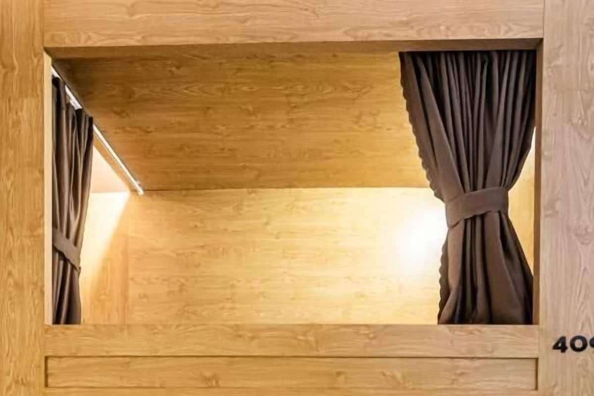 Una cama litera con cortinas, un cabecero de madera y el número '410' en la pared.