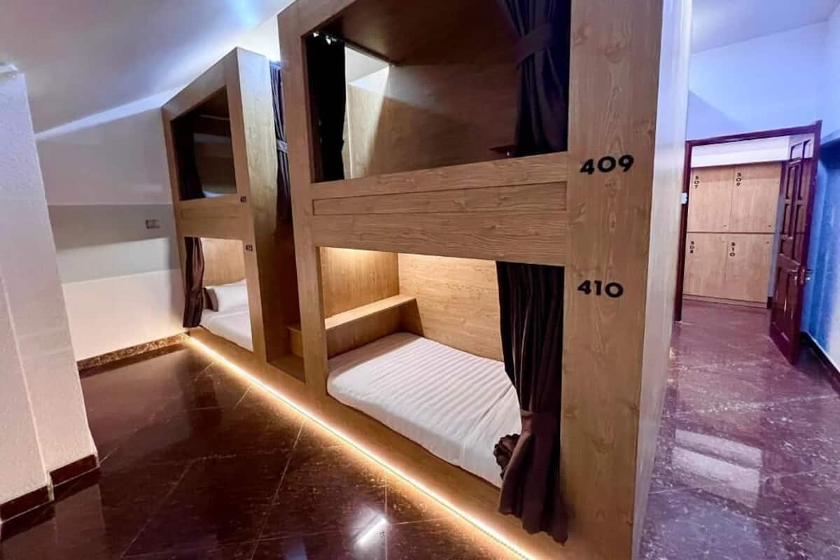 Habitación de hotel con literas, números 409 y 410, paredes de madera y suelo de mármol.