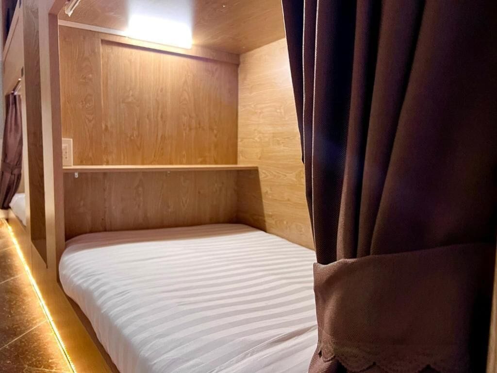 A single bed with a wooden headboard and a white mattress.