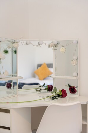 A white vanity with a mirror, surrounded by decorative lights and roses. - 4 bedroom house,  sleeps 8, fast WIFI, shops, long stays, pet friendly (Nelson)